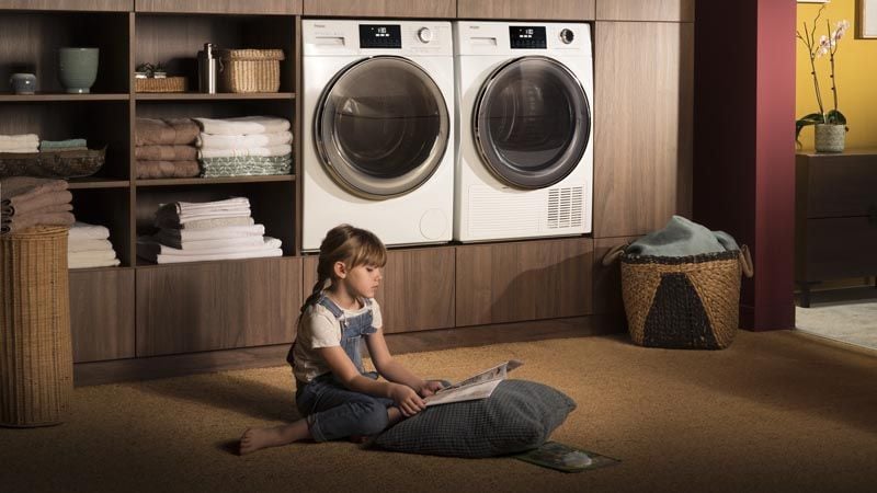 Lave-linge Haier silencieux Direct Motion en buanderie avec enfant qui lit à côté
