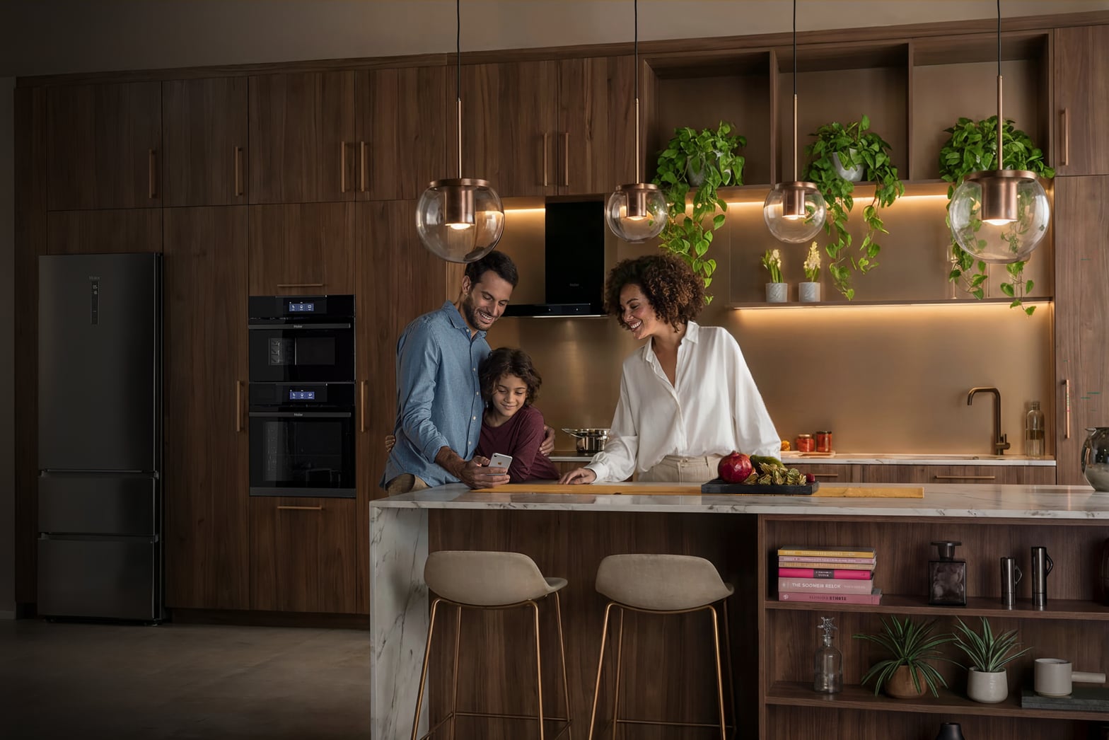Famille en cuisine moderne utilisant l'application hOn pour contrôler les appareils électroménagers connectés