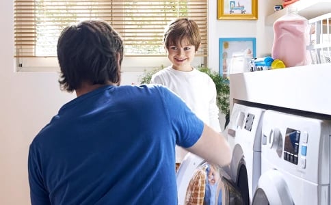 Pere et fils devant lave-linge Indesit utilisant cycle rapide Push and Go